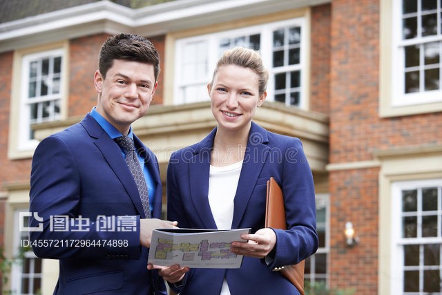 站在住宅物業(yè)外面的男女房地產(chǎn)經(jīng)紀人Male And Female Realtor Standing Outside Residential Property